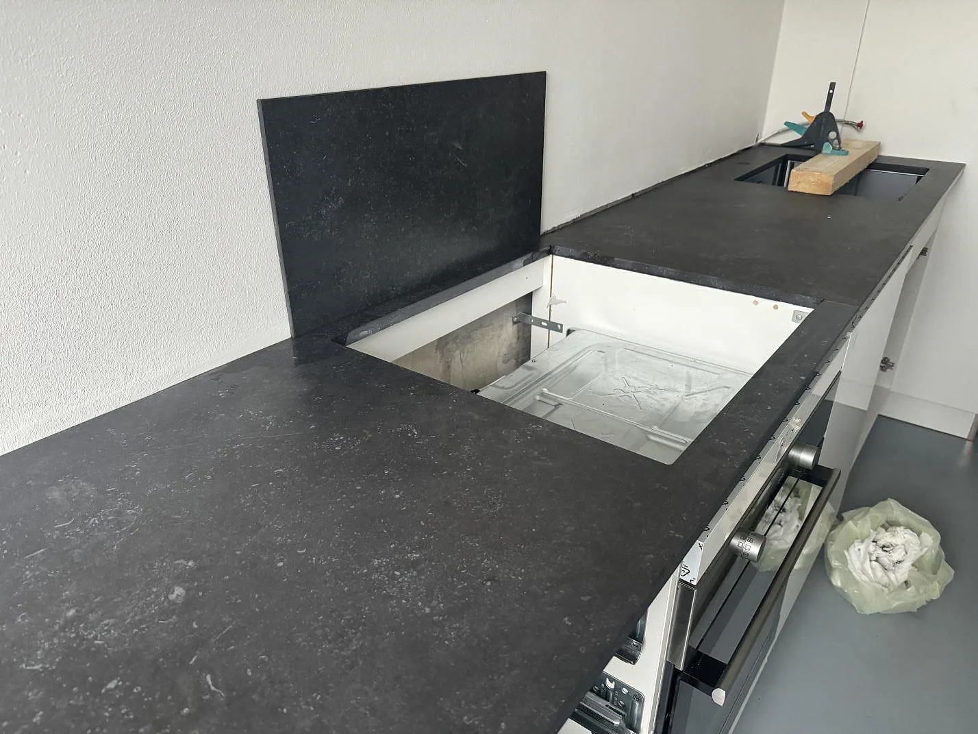 Närbild av matt Dekton Fossil vid underlimmad diskho och mörk stänkkant i ett kök i Hellerup.