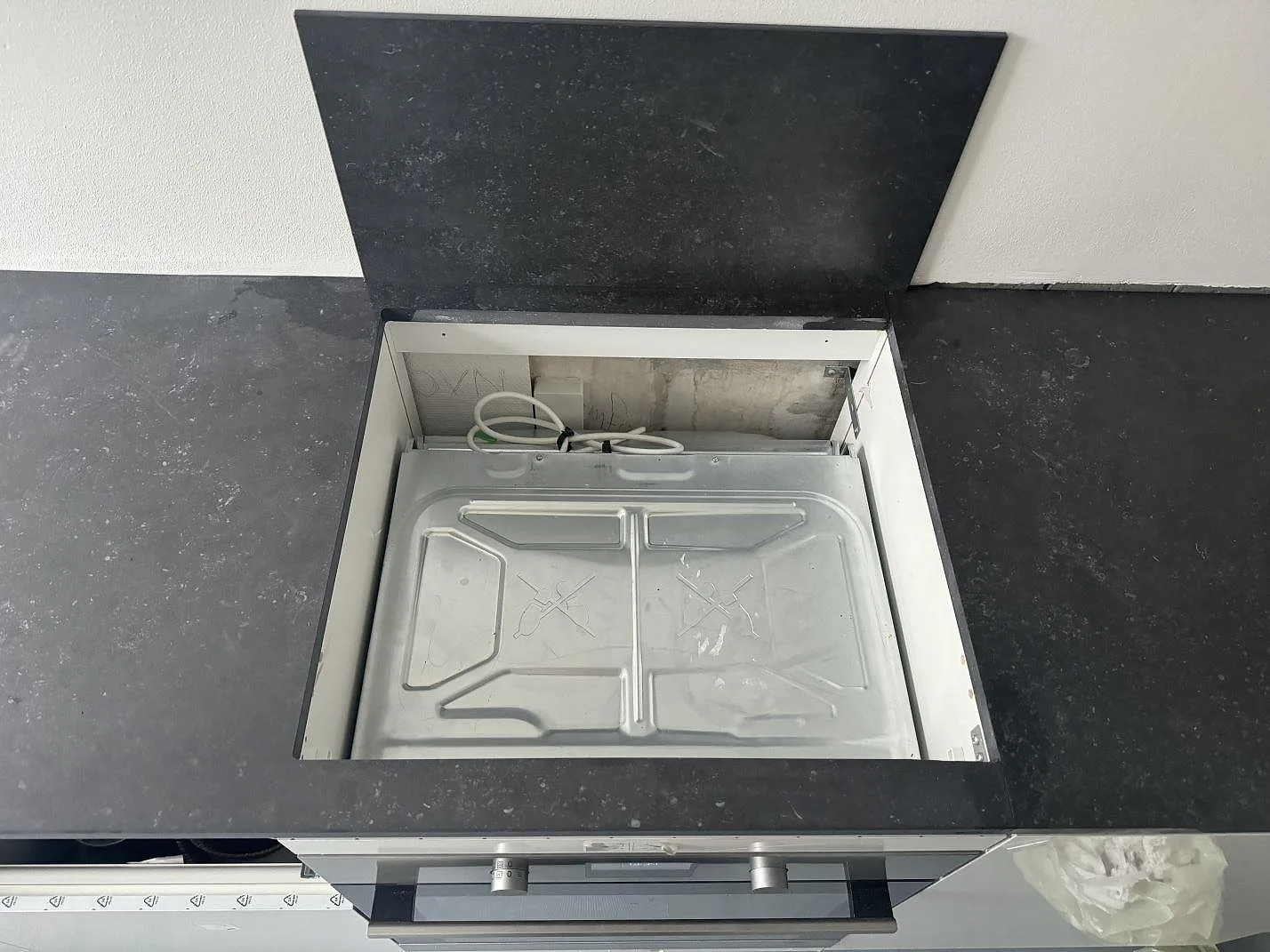 Ovanifrån på matt Dekton Fossil med stor öppning i bänkskivan och stänkkant bakom i Hellerup.