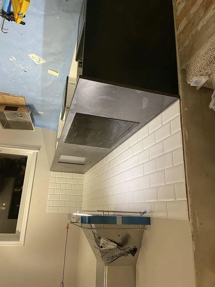Köksbänkskiva i Dekton Fossil med urtag för underlimmad diskho och synlig vattenanslutning under montering i Höllviken.