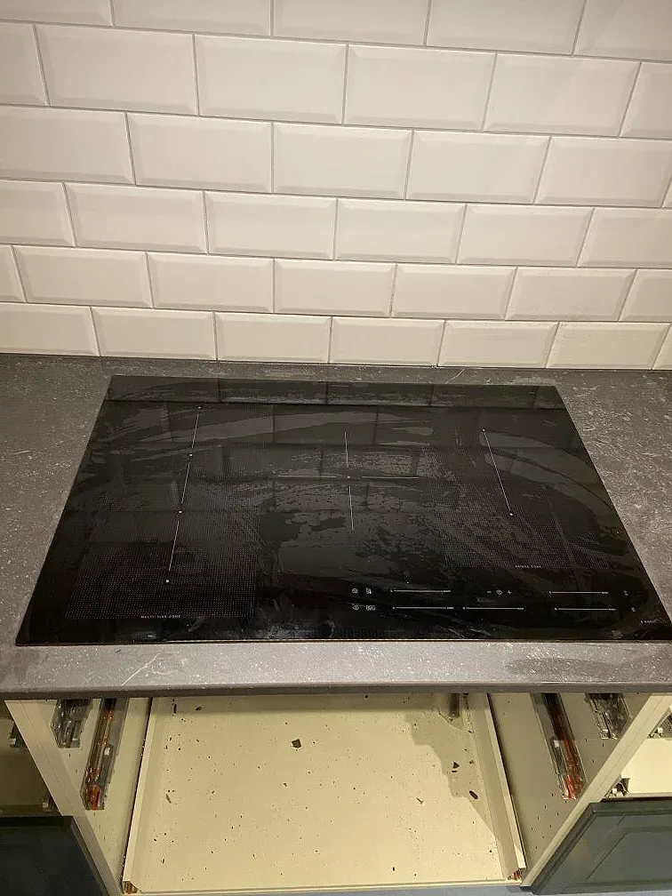 Köksbänkskiva i Dekton Fossil med oljad ekhylla i bakgrunden under montering i Höllviken.