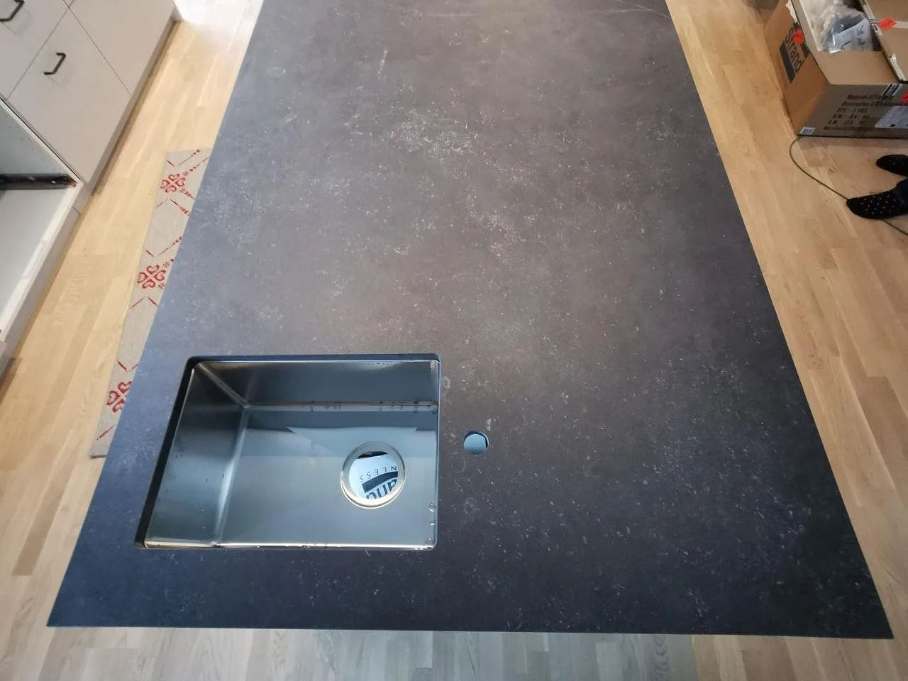 Köksö i Dekton Fossil ovanifrån med underlimmad rostfri diskho och blandarehål i ett kök i Landvetter.