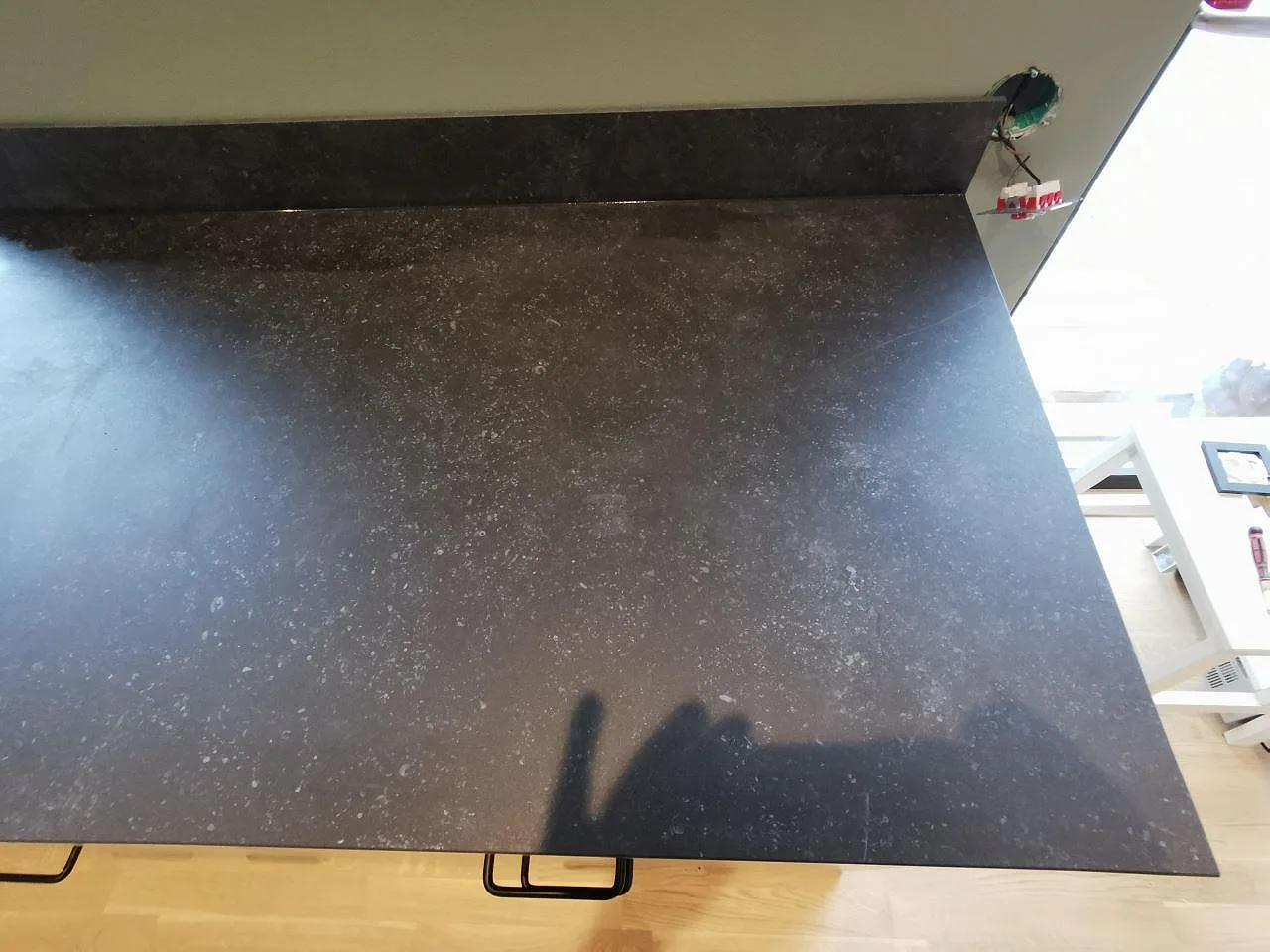 Bänkskiva i Dekton Fossil sedd från sidan, matt yta med fönsterläge i ett kök i Landvetter.