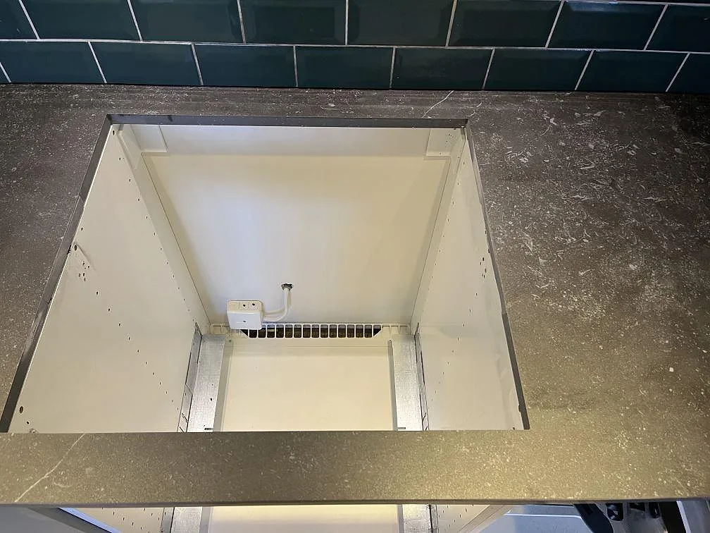 Urtag för häll i en köksbänkskiva i Dekton Fossil keramik över öppen köksstomme i ett kök i Timmele.