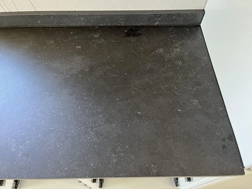 Bänkskiva i mörk Dekton Fossil sedd ovanifrån, monterad på köksskåp i ett kök i Uddevalla.
