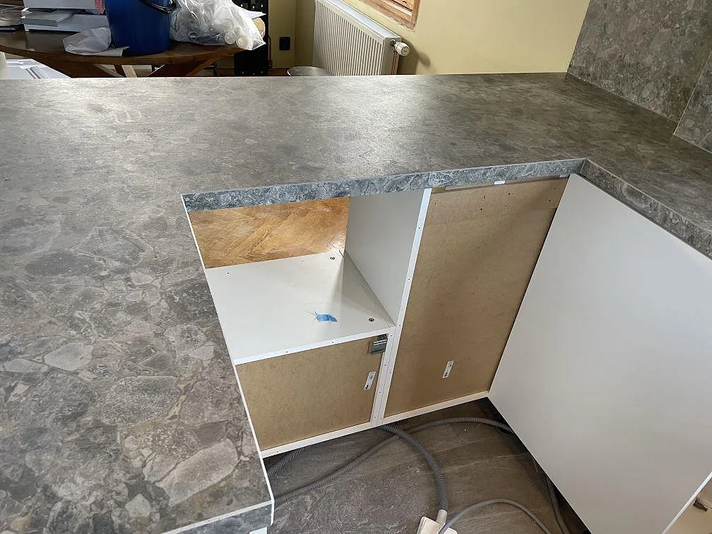 Installerad bänkskiva i matt Dekton GK07 Ceppo med sidoklädd kant och stänkskydd under montering i Västra Frölunda.