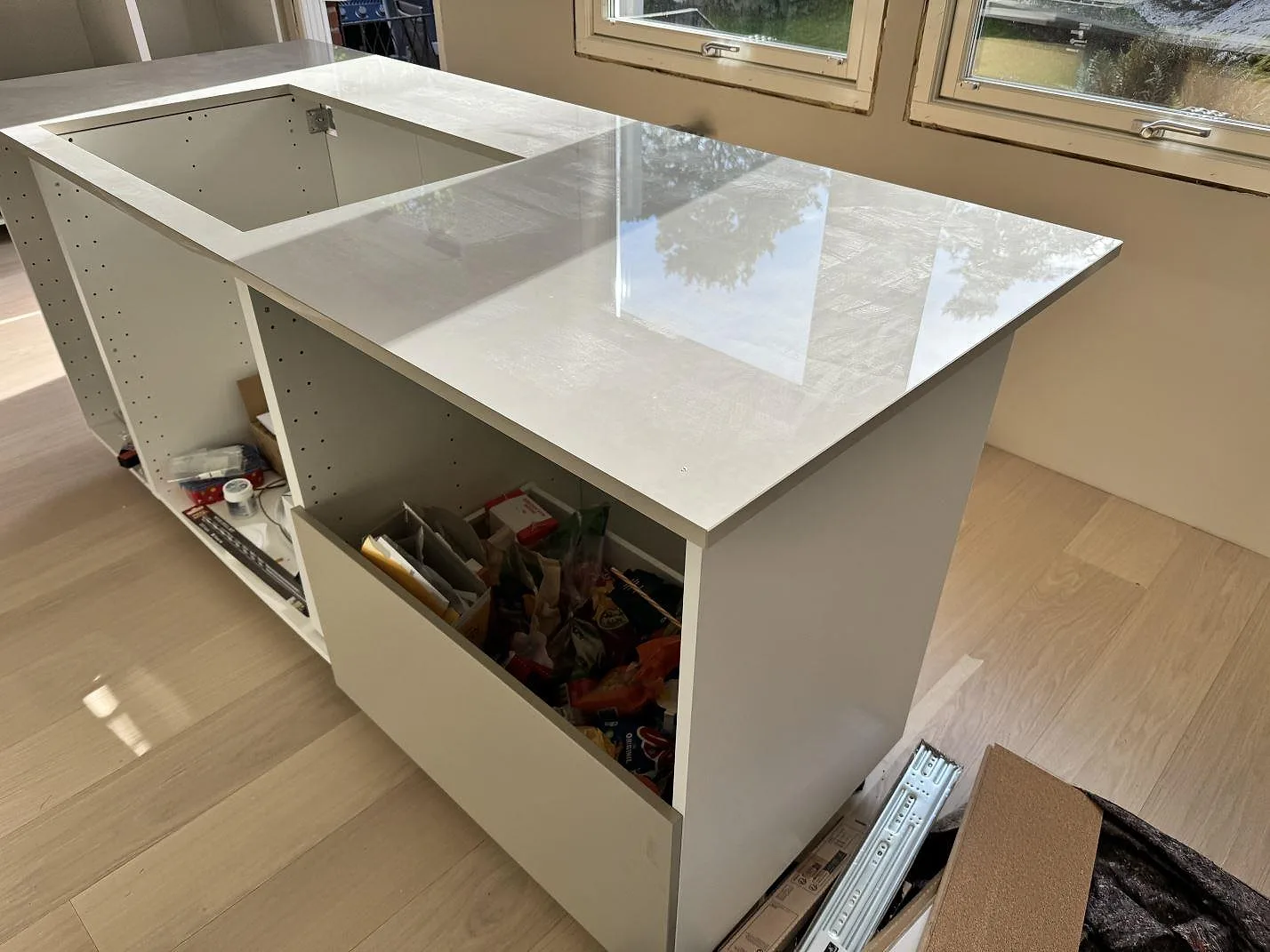 Polerad bänkskiva i Dekton Helena med blank yta och öppna köksstommar i ett kök i Göteborg.