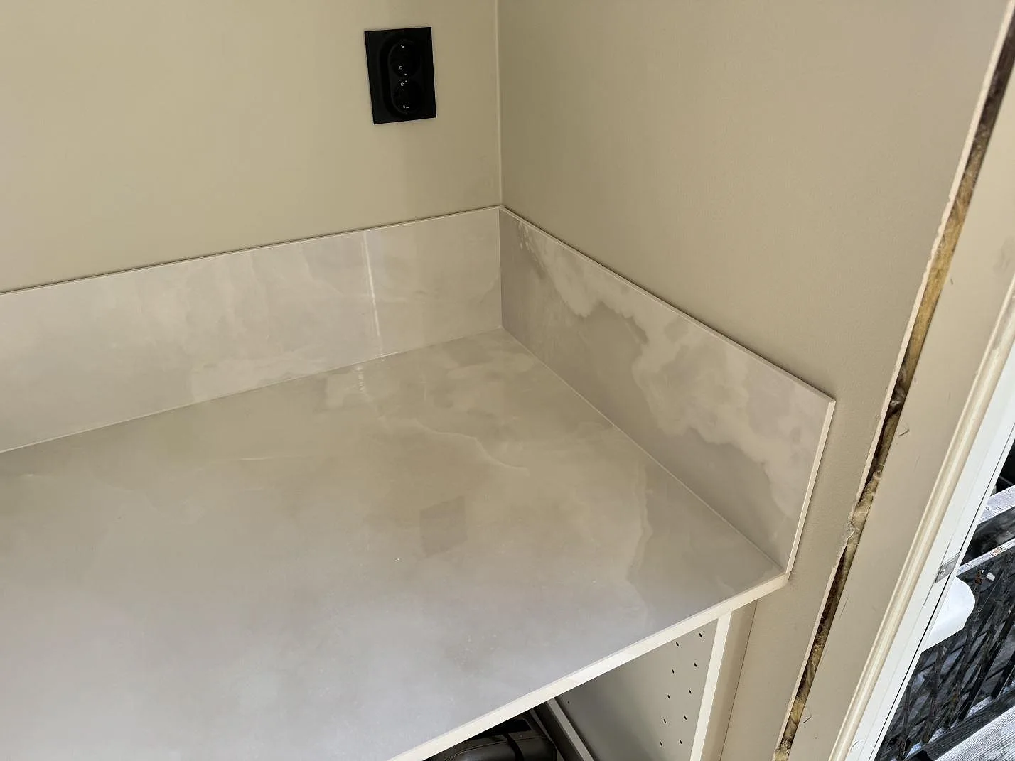 Väggbänk i polerad Dekton Helena med lågt stänkskydd i samma keramik i Göteborg.