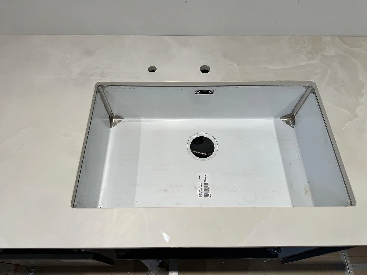 Detalj av diskzonen i polerad Dekton Helena, vit marmorerad keramik, monterad i ett kök i Helsingborg.