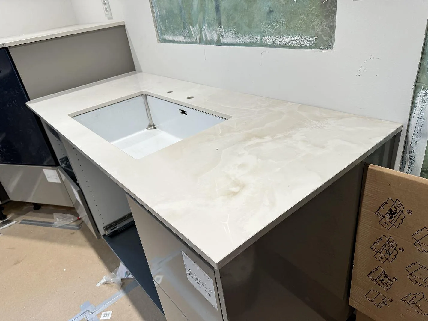 Polerad köksbänkskiva i Dekton Helena med diskzon och bred arbetsyta på mörka stommar i Helsingborg.