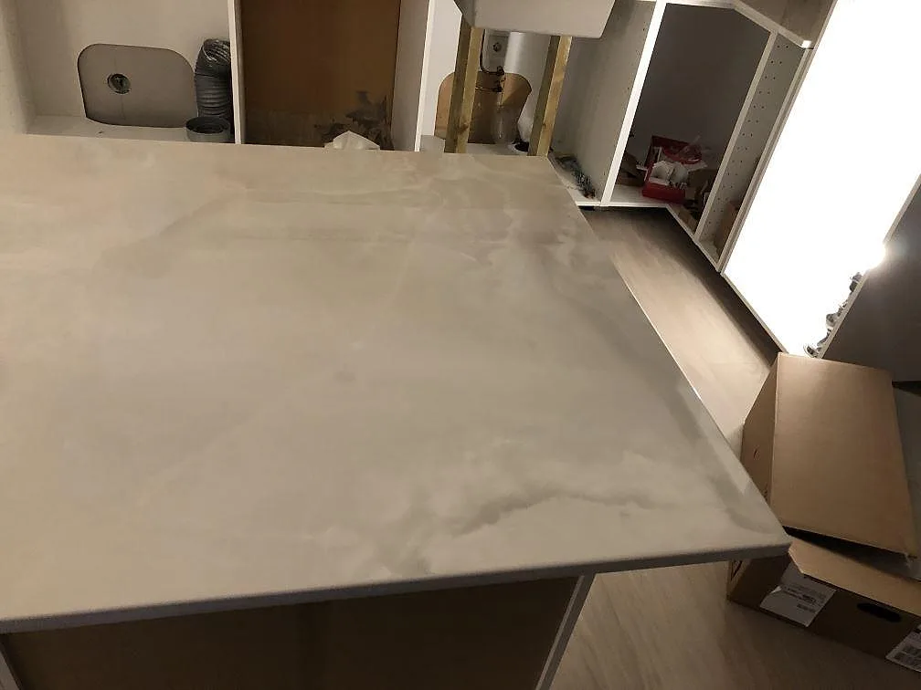 Bänkskiva i Dekton Helena med molnig grå ådring sedd ovanifrån i ett kökshörn under montering i Lessebo.