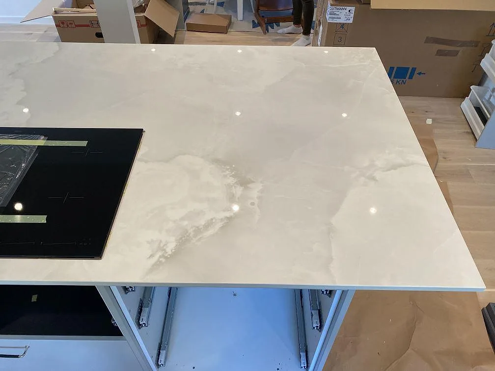 Köksö i Dekton Helena, polerad keramikbänkskiva med induktionshäll, fotograferad ovanifrån under montering i ett kök i Malmö.