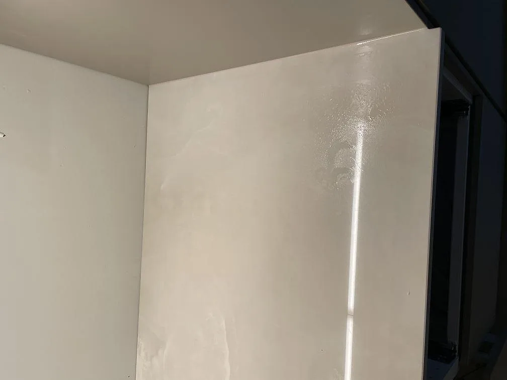 Närbild på den polerade ytan och grå ådringen i Dekton Helena bänkskiva i ett kök i Ramlösa.
