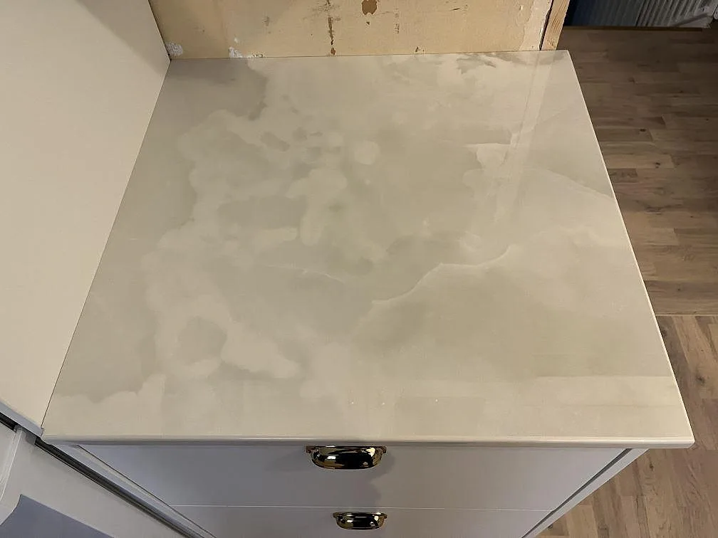 Närbild på polerad Dekton Helena köksbänkskiva med ljus ådring och blank yta i Storebro.