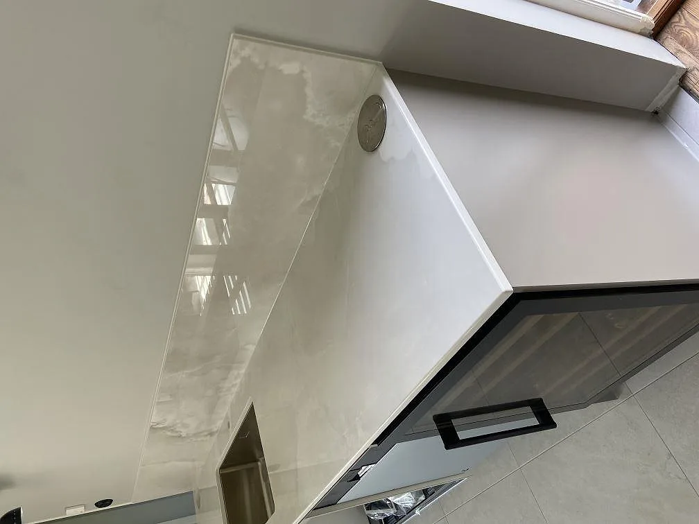 Bänkskiva i polerad Dekton Helena med eluttag och fönsterbänk i ett kök i Ystad.