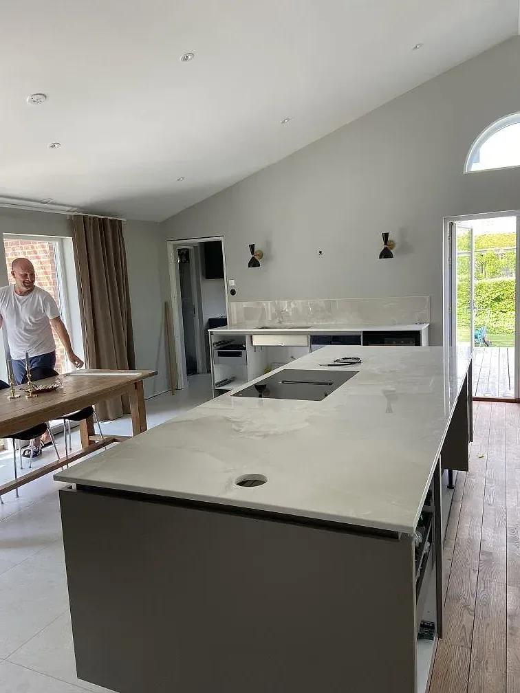 Polerad Dekton Helena-bänkskiva sedd från sidan med diskrokär och ådring i ett kök i Ystad.