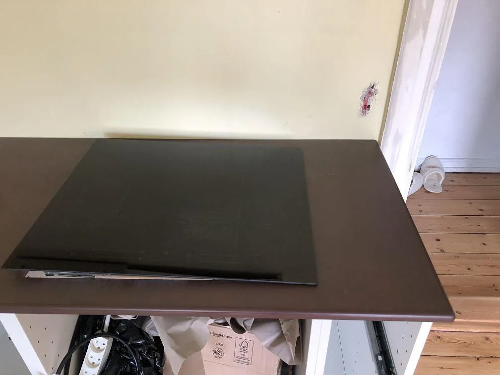 Köksbänkskiva i mörkbrun Dekton Kadum med två underlimmade rostfria diskhoar och borrat hål för köksblandare i ett kök i København NV.