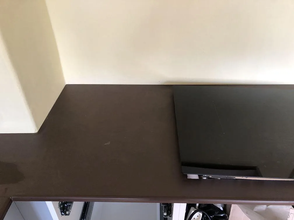 Detalj av två underlimmade rostfria diskhoar i en matt mörkbrun Dekton Kadum köksbänkskiva i København NV.