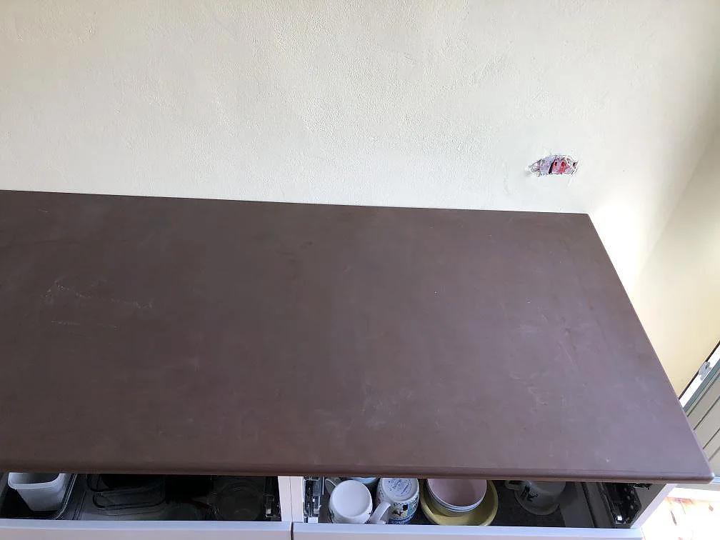 Matt mörkbrun Dekton Kadum bänkskiva med induktionshäll längs köksön i ett kök i København NV.