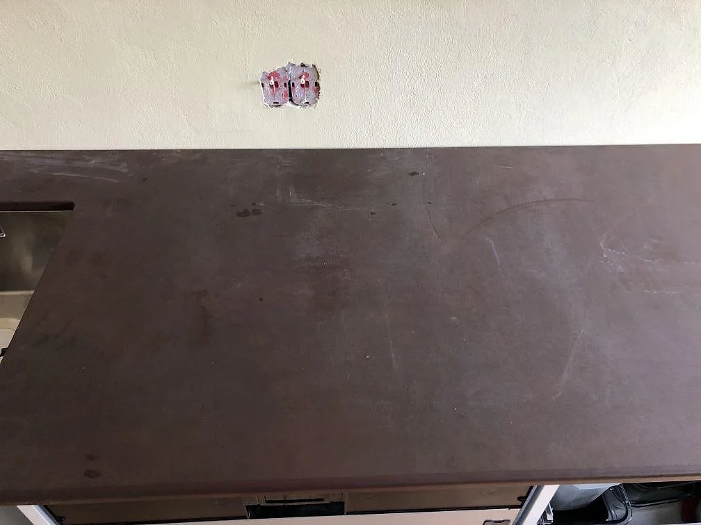 Mörkbrun Dekton Kadum köksbänkskiva i matt betongton sedd ovanifrån i ett kök under montering i København NV.