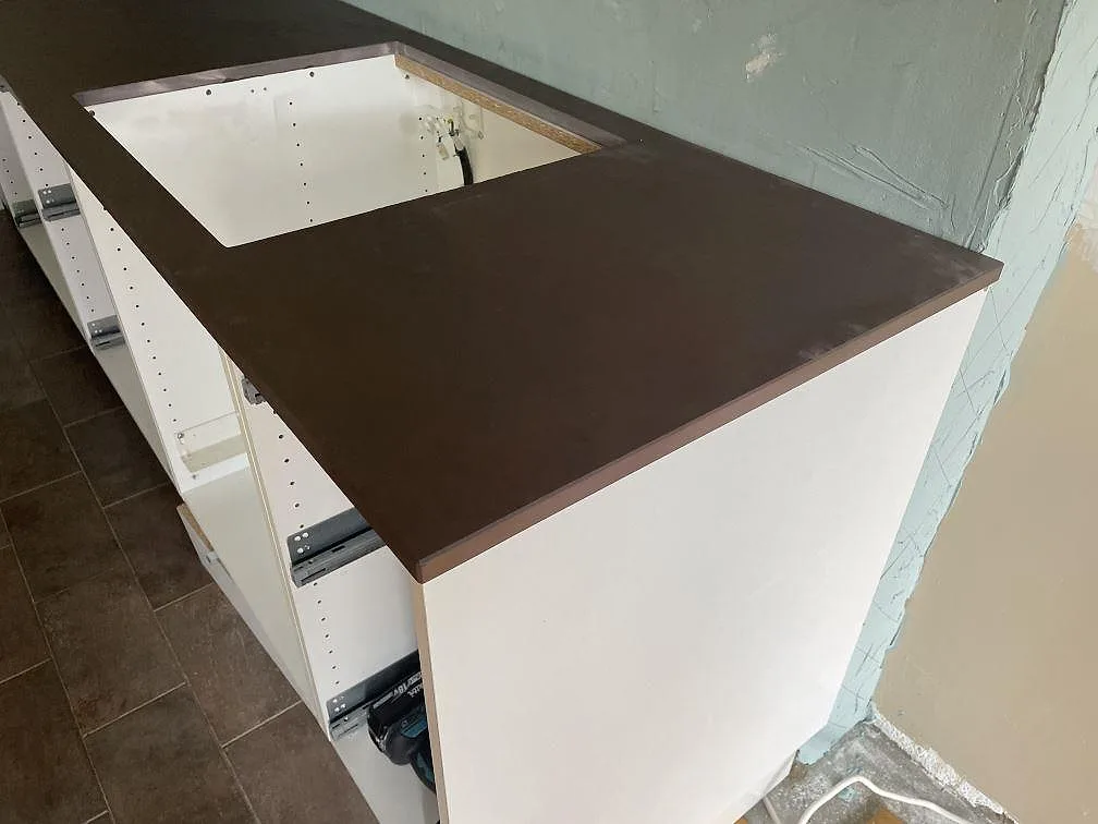Installerad köksbänkskiva i matt Dekton Kadum på vita köksstommar med stor utskärning i Mölndal.