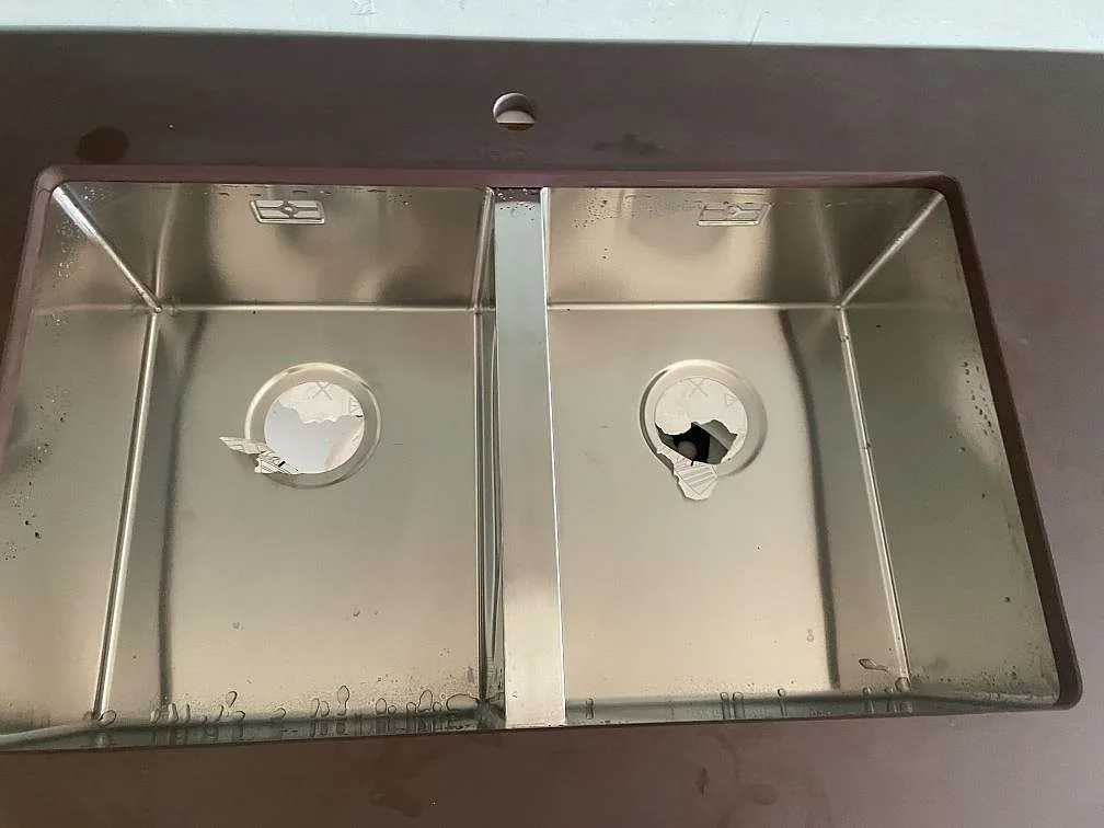 Närbild på dubbel underlimmad rostfri diskho i en matt Dekton Kadum köksbänkskiva i Mölndal.