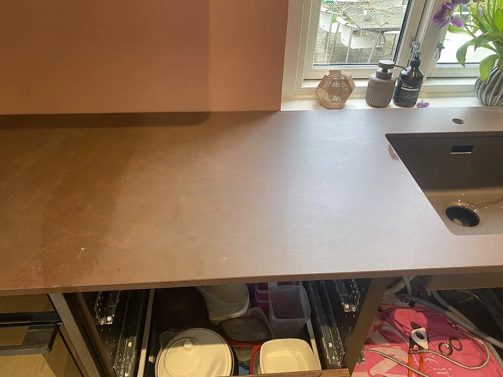 Köksrad i Dekton Kadum, matt keramik, med underlimmad komposithoar under fönstret i ett kök i Valby.