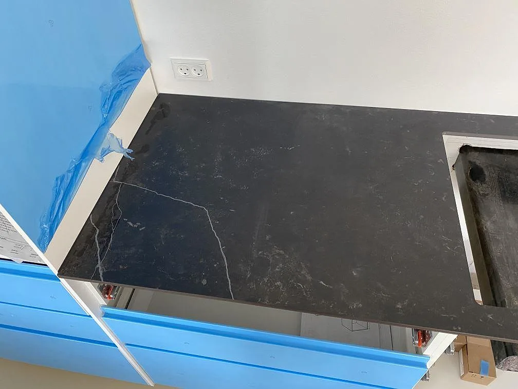 Närbild av vänstra bänkdelen i matt Dekton Kelya, mörk keramik med ådring och urtagning i köket i Birkerød.