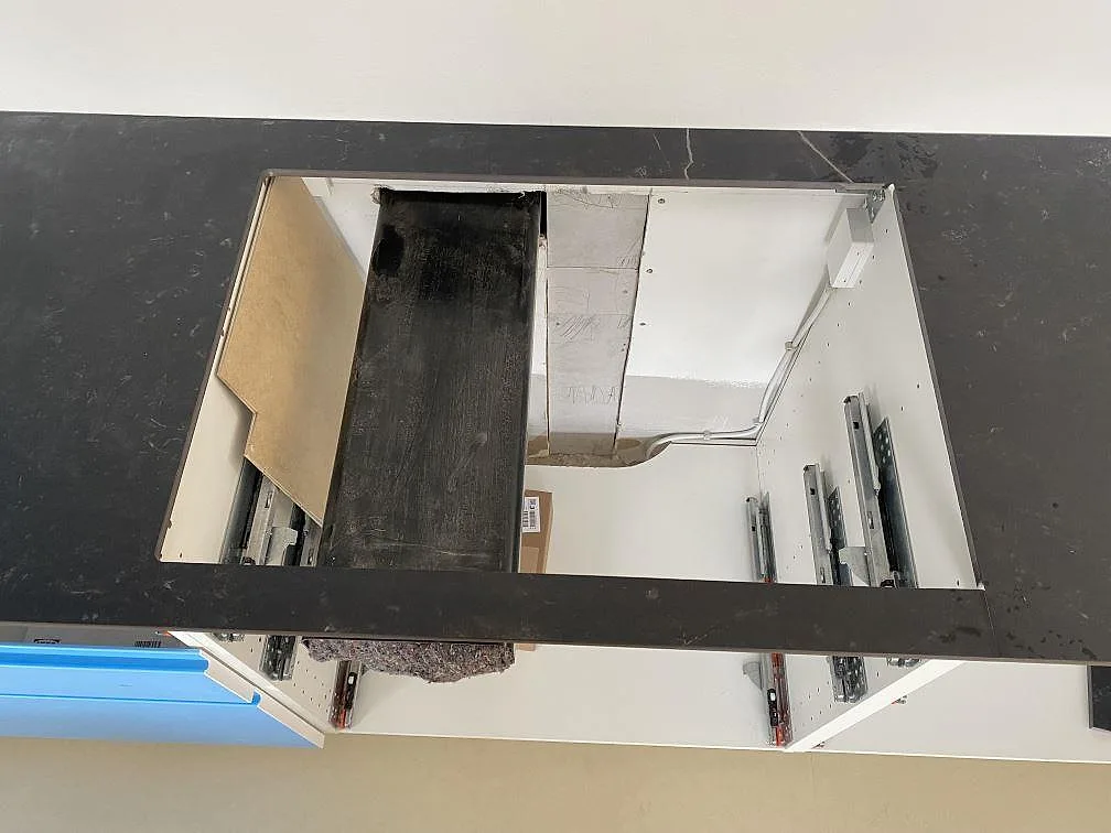 Detalj av matt Dekton Kelya-bänkskiva i keramik med stor rektangulär urtagning över köksstommar i Birkerød.