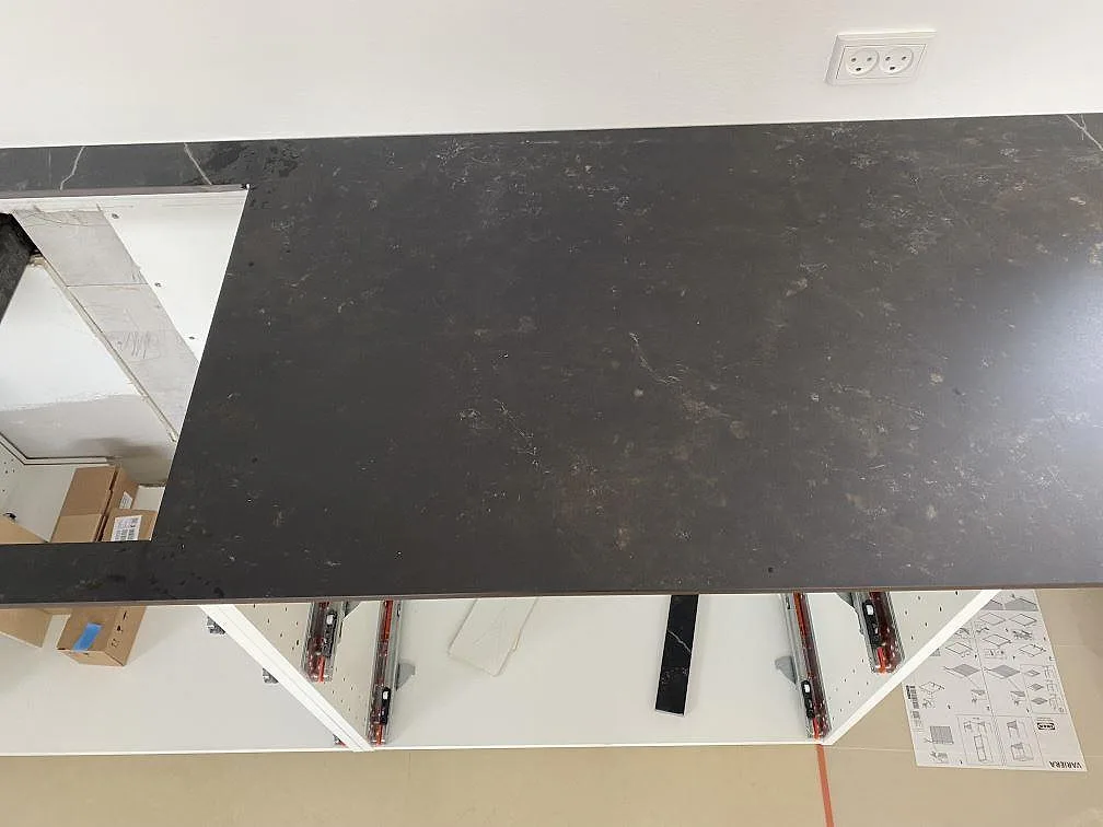 Topvy över installerad matt Dekton Kelya-bänkskiva i keramik, med öppen köksstomme under montering i Birkerød.