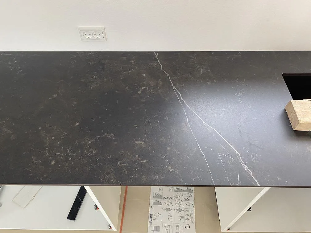 Närbild på lång matt Dekton Kelya-bänkskiva i mörk keramik med tydlig ljus åder i köket i Birkerød.