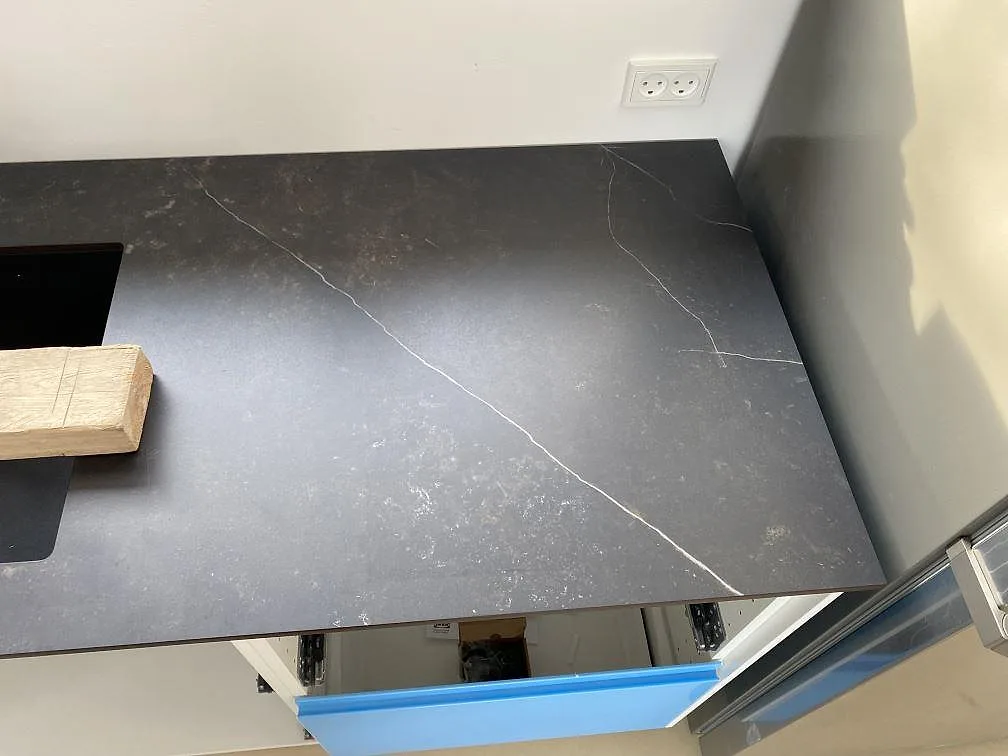 Detalj av matt Dekton Kelya i keramik vid fönstersidan, med ljus ådring över köksstomme i Birkerød.