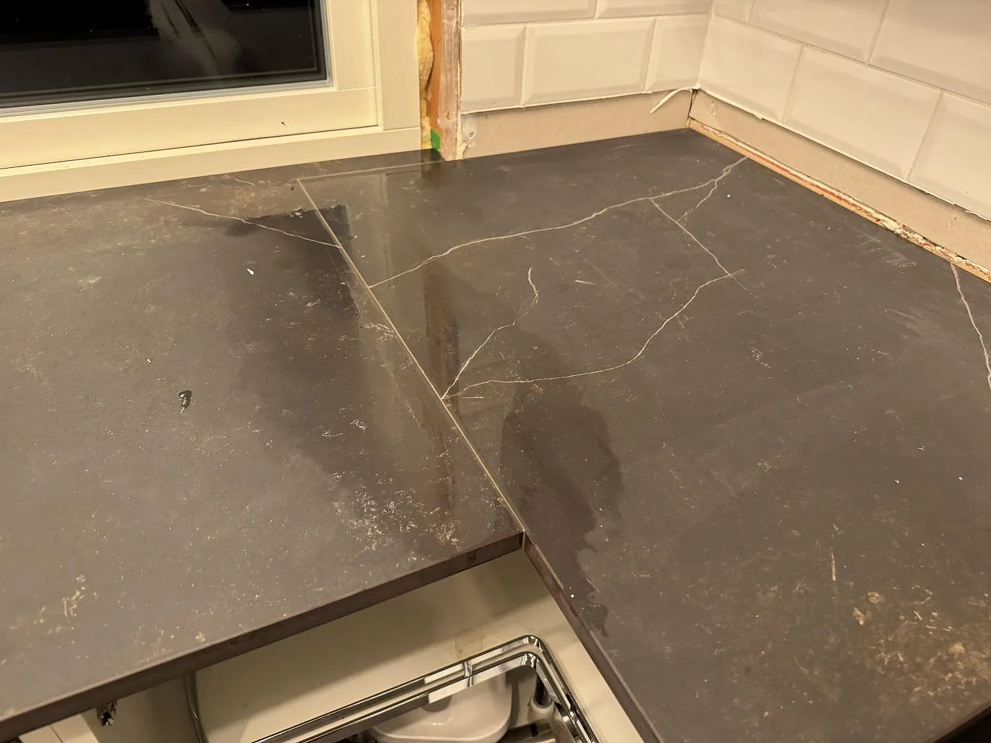 Hörndetalj i matt Dekton Kelya där bänkskivan fortsätter mot fönstret i ett kök i Borås.