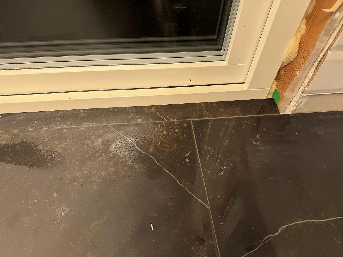 Fönsternära bänkyta i matt Dekton Kelya med markerad ådring och mörk keramik i Borås.