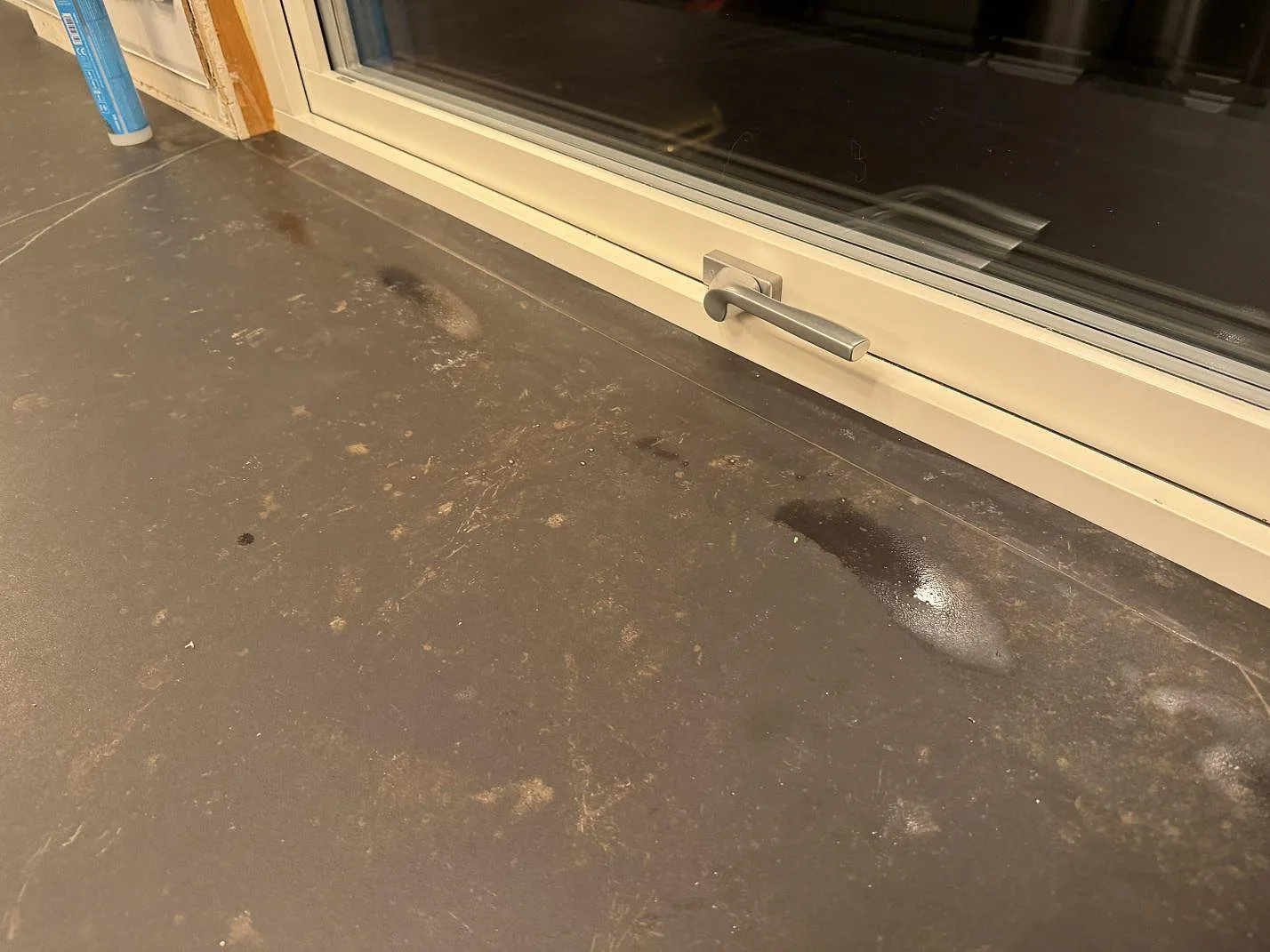 Närbild på matt Dekton Kelya vid fönster, med mörk yta och ljusa ådror i köket i Borås.