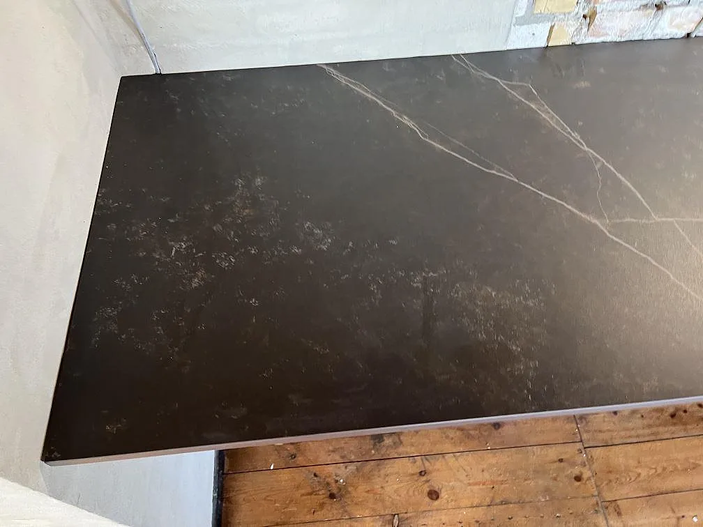 Köksbänk i mörk matt Dekton Kelya med ljus ådring mot vägg i ett kök i Fårevejle.