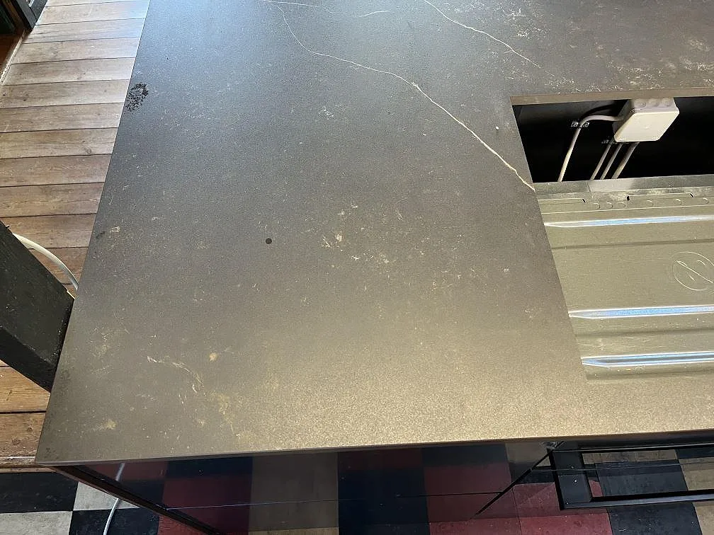 Köksbänkskiva i matt Dekton Kelya sedd ovanifrån med urtag för häll i ett kök i Fårevejle.