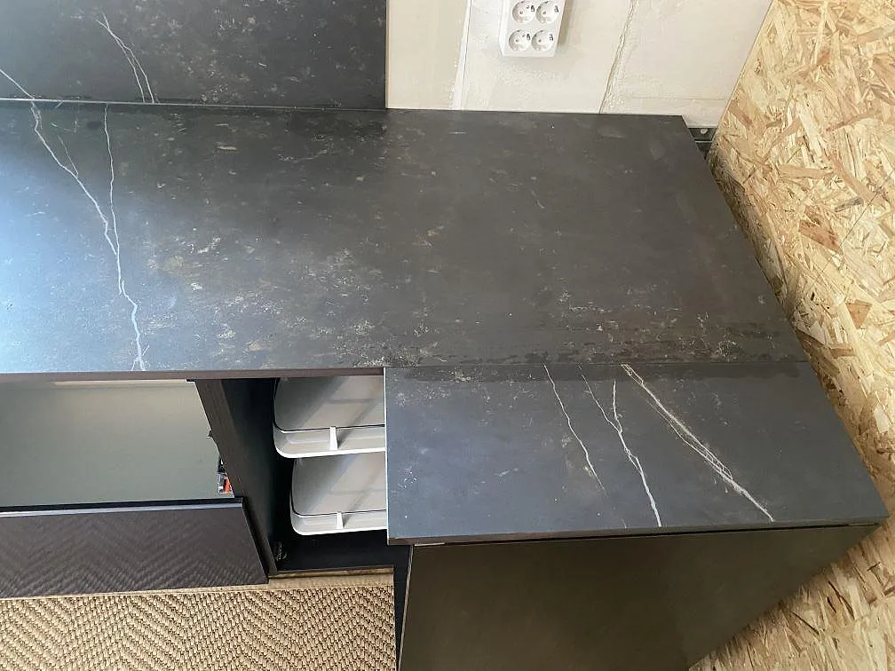 Köksbänkskiva i svart Dekton Kelya med vit ådring, matt yta, i ett vinkelkök under montering i Genarp.