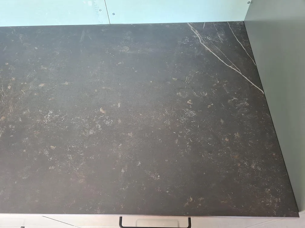 Närbild av bänkskiva i matt Dekton Kelya keramik med ljusa vener längs kanten i Glanshammar.