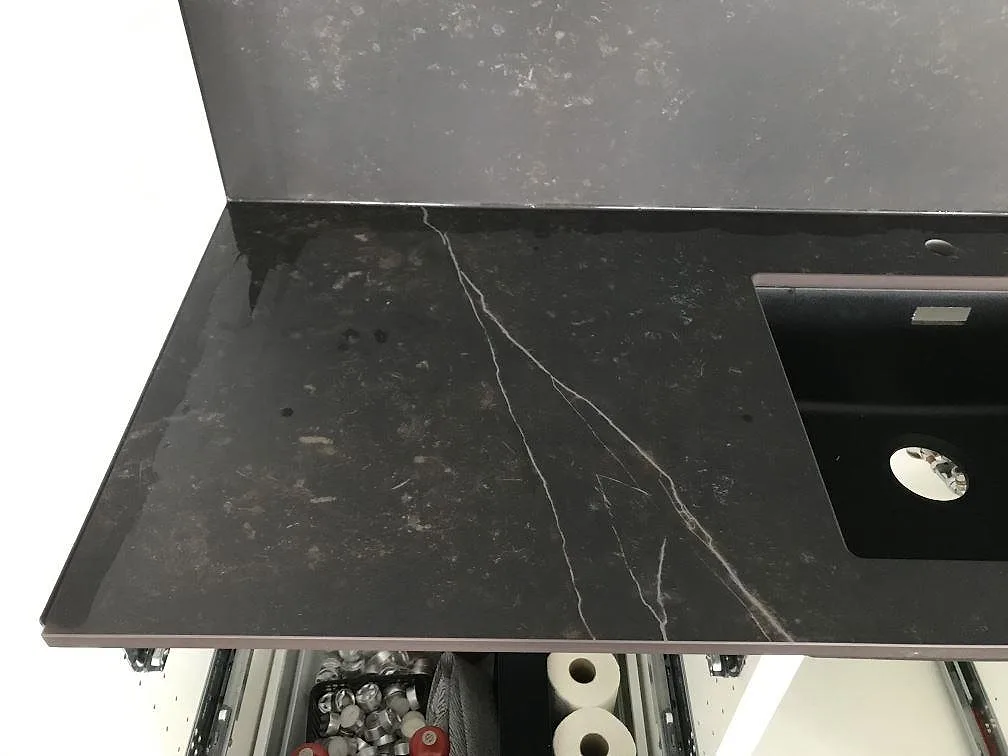 Köksbänkskiva i svart Dekton Kelya med underlimmad diskho och uppvikt stänkskydd i matt keramik i Göteborg.