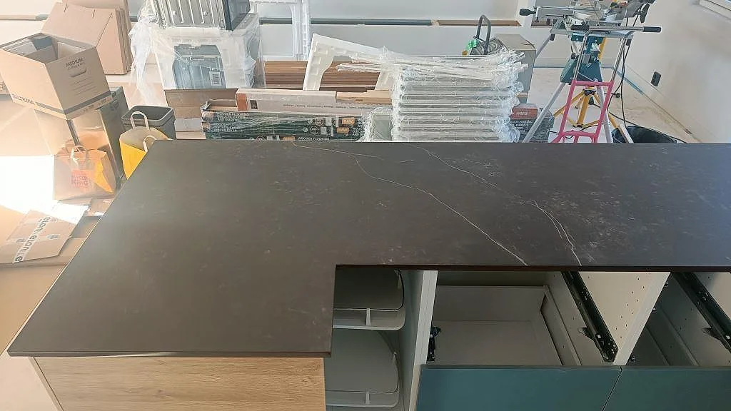 Toppvy av installerad L-bänk i mörkgrå Dekton Kelya keramik i ett kök i Hässleholm.