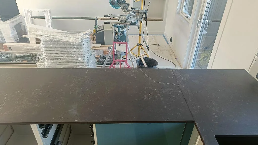 Lång bänkskiva i matt Dekton Kelya med synlig ådring i ett kök i Hässleholm.