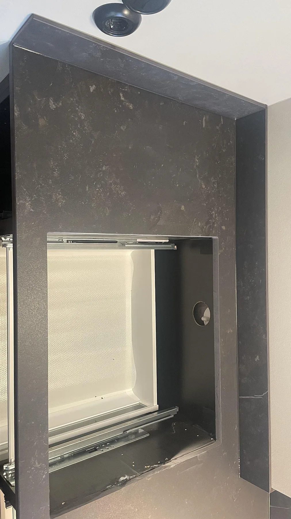 Vertikal stänkdel i matt Dekton Kelya monterad runt en öppen köksstomme i Helsingborg.