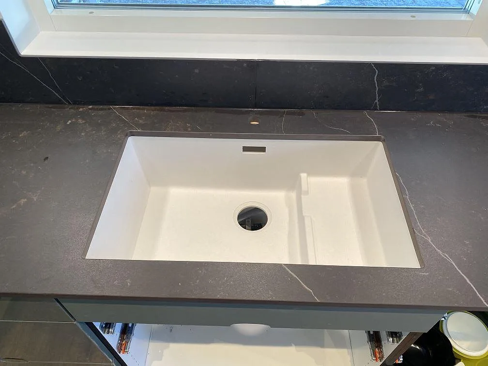 Mörkgrå Dekton Kelya bänkskiva med ljus mineralådring sedd uppifrån i ett kök i Höör.