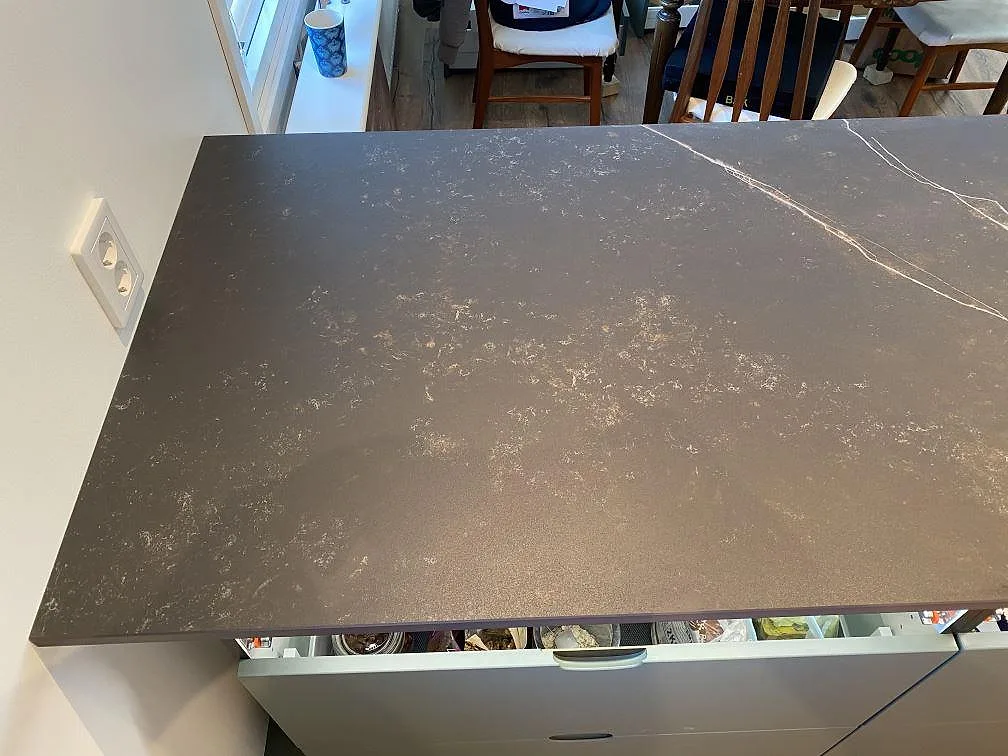 Köksö i mörkgrå Dekton Kelya med tydlig ljus ådring, matt yta, i ett kök i Höör.
