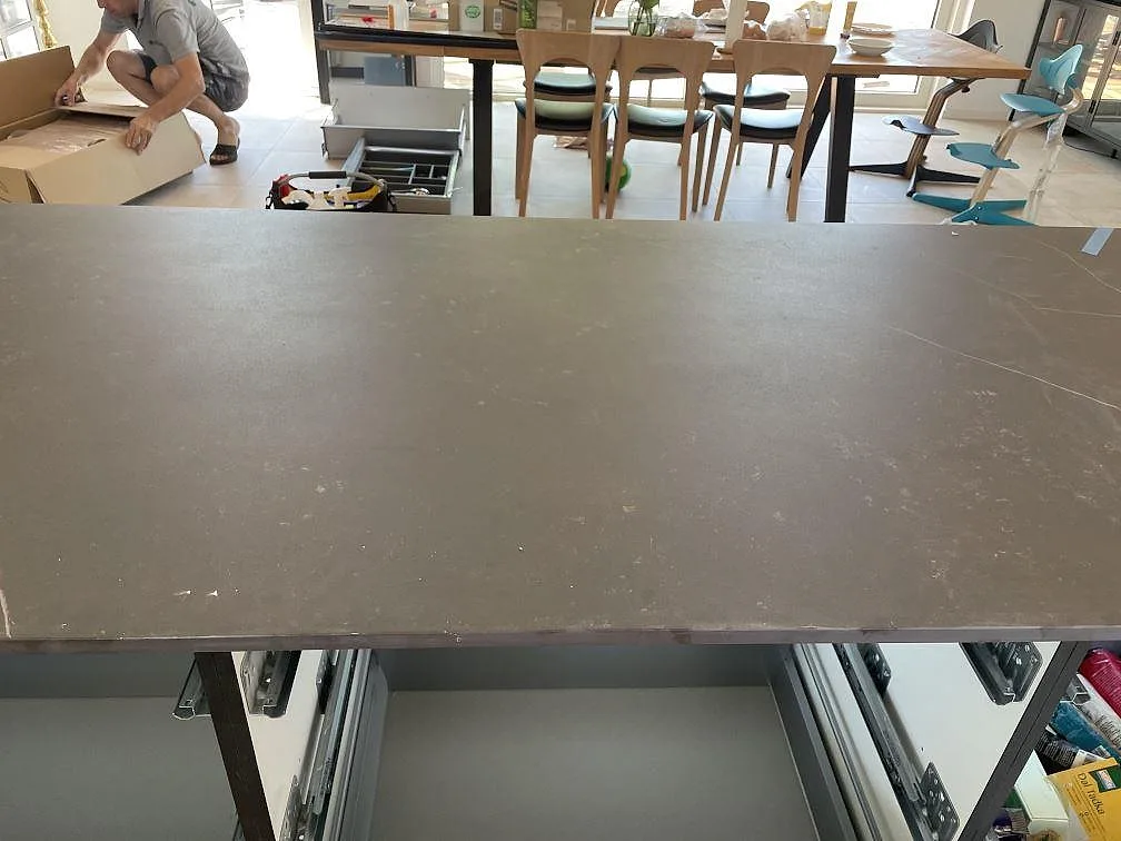 Detaljbild av matt Dekton Kelya på köksö under montering, med mörk yta och ljus ådring i Hørsholm.