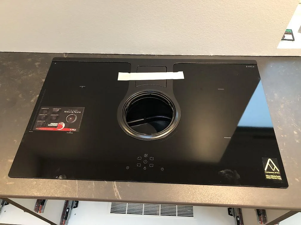 Infälld induktionshäll med integrerad fläkt i köksö av Dekton Kelya i matt keramik i ett kök i Hvidovre.