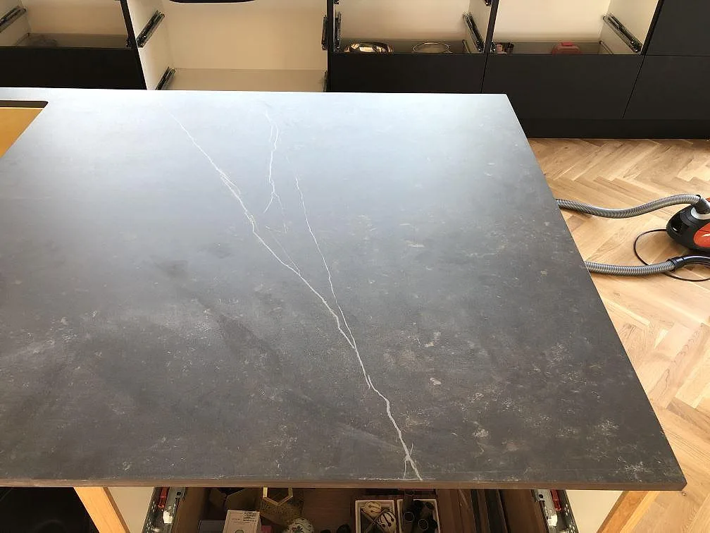 Stor köksö i svart matt Dekton Kelya med ljus ådring sedd uppifrån i ett kök i Jyderup.