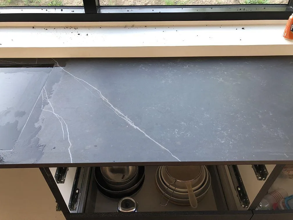 Närbild på underlimmad mässingsfärgad diskho i en köksö av Dekton Kelya i ett kök i Jyderup.