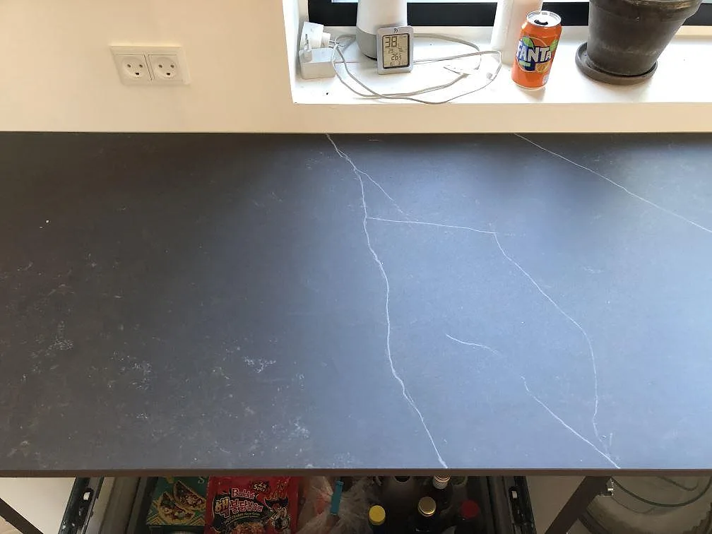 Köksbänkskiva i mörk Dekton Kelya, matt keramik med fina ljusa ådror, i ett kök i Jyderup.