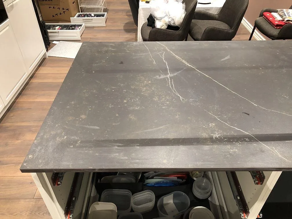 Öppen köksö med bänkskiva i Dekton Kelya, matt, och ljusa ådror i Kärna.